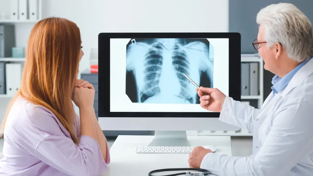 Médico a explicar um exame de imagem dos pulmões durante a avaliação de uma pessoa com fibrose pulmonar.