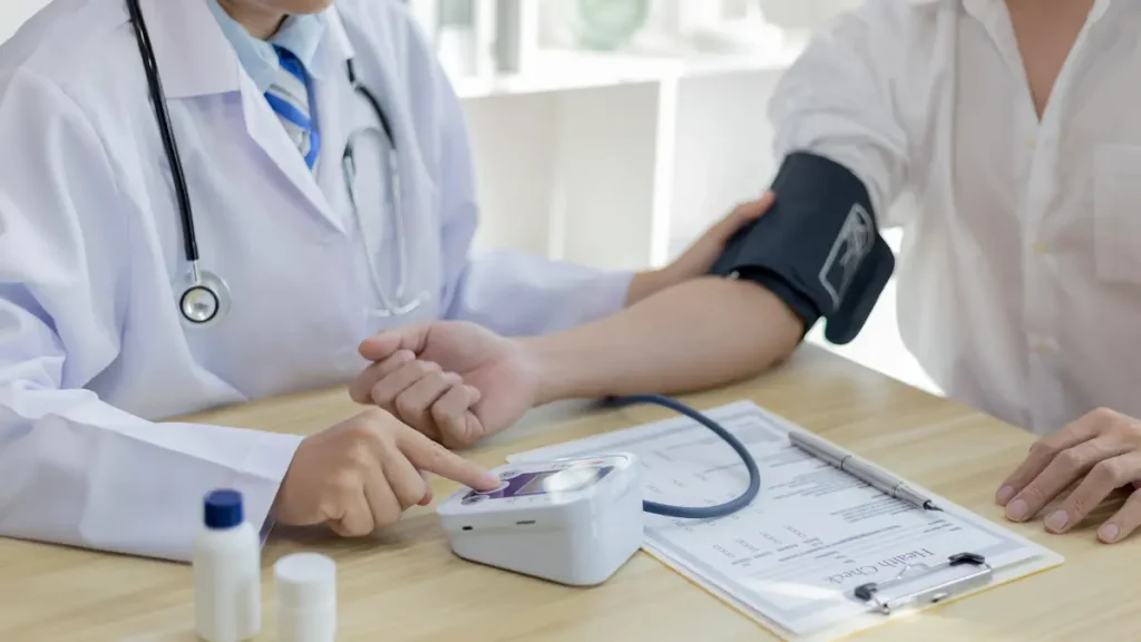 Profissional de saúde a medir a tensão arterial durante um check-up médico de rotina.